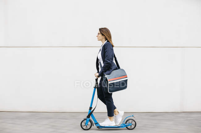 Activa empresaria montando scooter en la ciudad - foto de stock