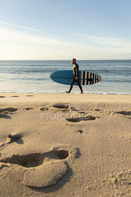 Cádiz, Andalucía, Tarifa, hombre caminando con stand up paddle board en la playa - foto de stock