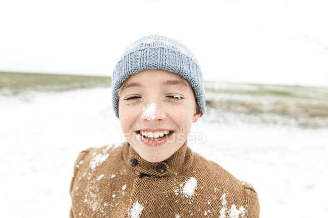 Щасливий хлопчик грає зі снігом взимку — стокове фото