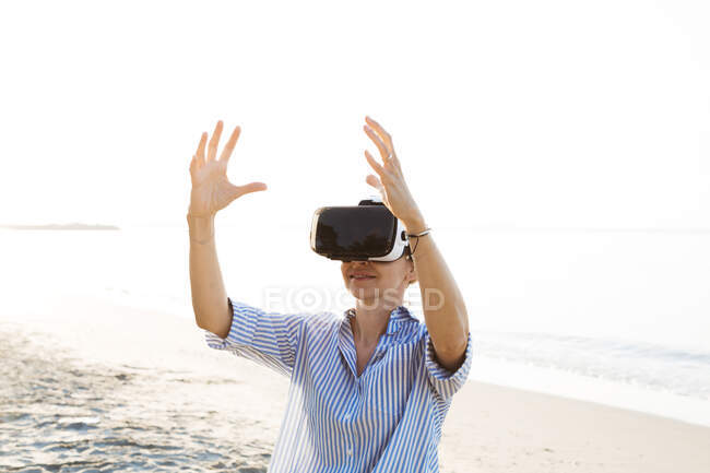 Tailândia, mulher usando óculos de realidade virtual na praia na luz da manhã — Fotografia de Stock