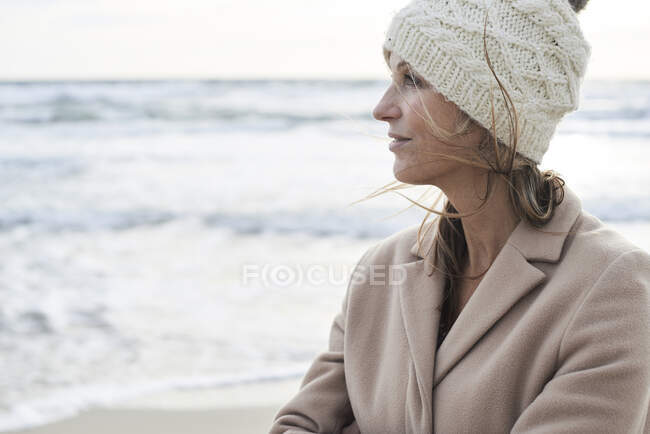 Испания, Менхенгладбах, портрет пожилой женщины в шерстяной шляпе на пляже зимой — стоковое фото