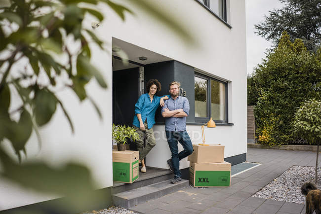 Coppia in piedi all'ingresso di casa con scatole di cartone — Foto stock