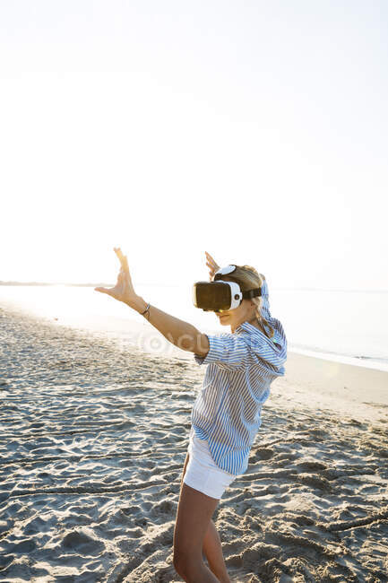 Thaïlande, femme portant des lunettes de réalité virtuelle sur la plage à la lumière du matin — Photo de stock