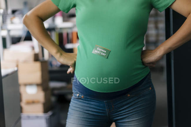 Adesivo di consegna sullo stomaco della donna incinta in ufficio — Foto stock