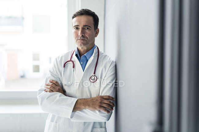 Retrato de médico sério encostado a uma parede — Fotografia de Stock
