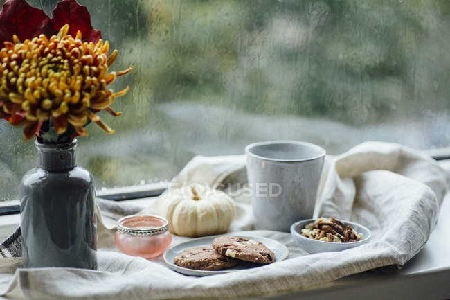 Cup of coffee, cookies and autumnal decoration on window sill — Stock Photo