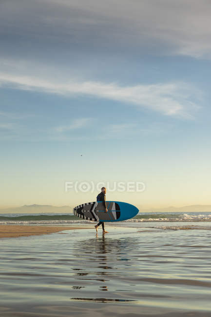 Espagne, Andalousie, Tarifa, homme marchant avec stand up paddle board sur la plage — Photo de stock