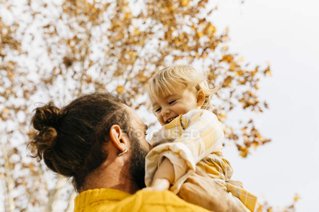 Восени батько тримає доньку в парку. — стокове фото