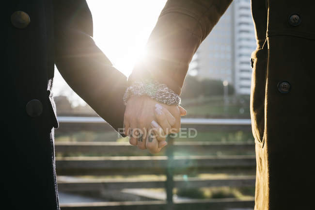 Close Up Of Couple Holding Hands In Backlight Happy Together Stock Photo