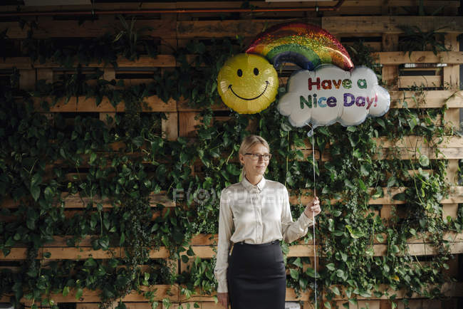 Geschäftsfrau im grünen Büro mit Luftballons — Stockfoto