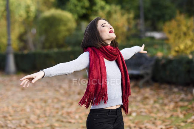 Mujer joven y feliz con bufanda roja en — Brazos extendidos, Hembra - Stock Photo #289706646