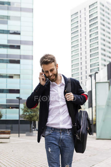 Stylish businessman talking on cell phone in the city — Stock Photo