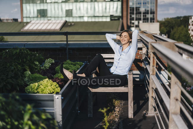 Geschäftsfrau entspannt sich in seinem urbanen Dachgarten — Stockfoto