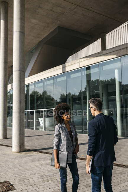 Two colleagues talking outside office building — Stock Photo