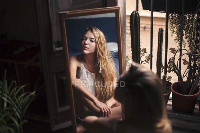 Imagem espelhada da jovem mulher assistindo a si mesma — Fotografia de Stock