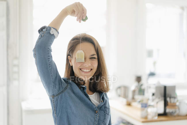 Mulher bonita segurando saco de chá, sorrindo — Fotografia de Stock