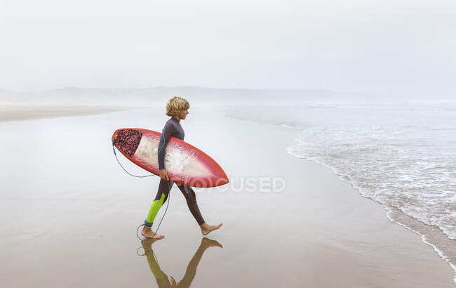 Spagna, Aviles, giovane surfista che cammina verso l'acqua — Foto stock