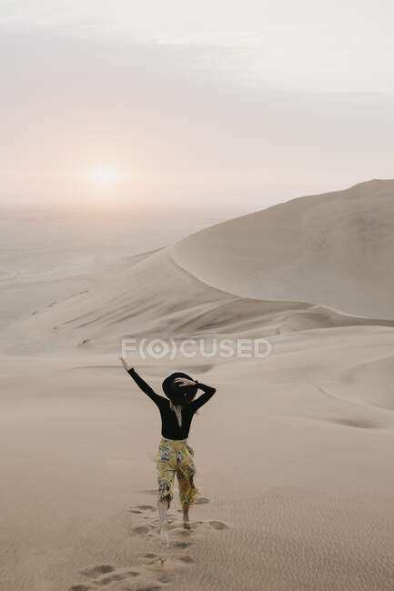 Namibia, Namib, vista posteriore della donna alla moda che salta sulla duna del deserto — Foto stock