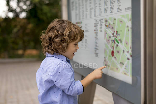 Хлопець, що дивиться на карту в місті. — стокове фото