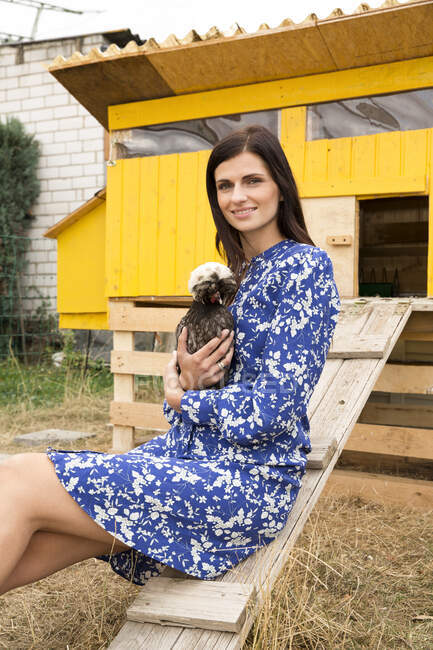 Porträt einer lächelnden Frau mit polnischen Hühnern im Hühnerstall im Garten — Stockfoto