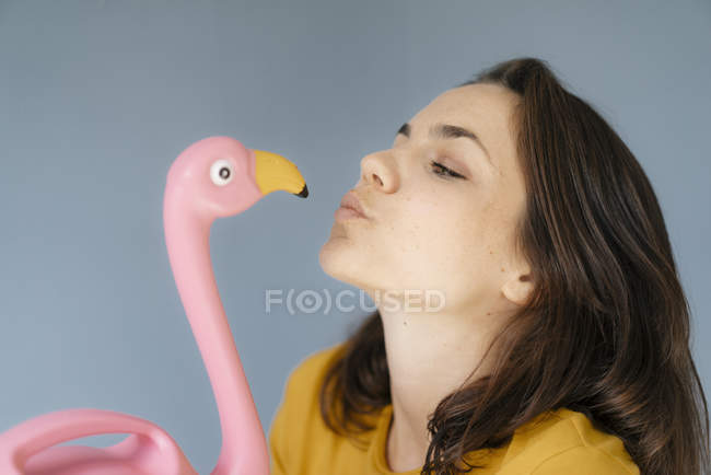 Frau küsst rosa Flamingo-Figur — Stockfoto