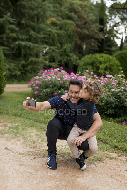 Feliz pai e filho em tirar uma selfie no parque — Fotografia de Stock
