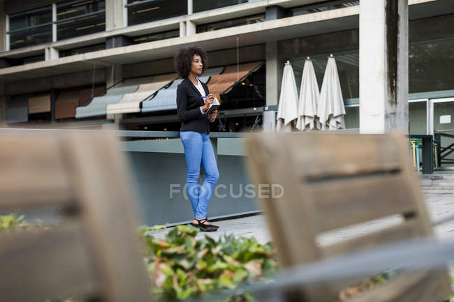 Бизнесмен с ноутбуком, стоящей на террасе и думающей: — стоковое фото