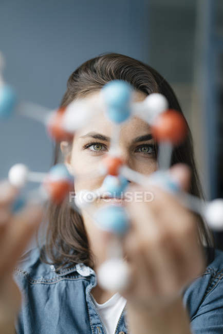 Wissenschaftlerin untersucht Molekülmodell und sucht nach Lösungen — Stockfoto