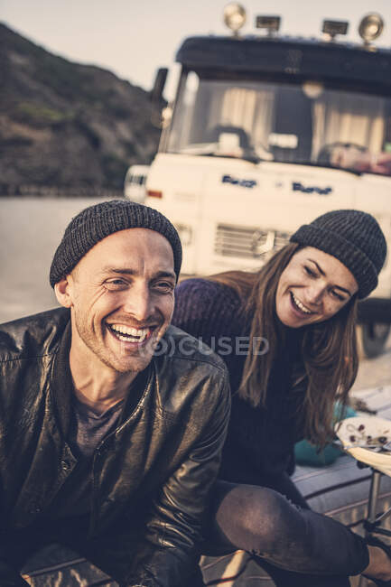 Ritratto di lauging man con fidanzata e camper sullo sfondo — Foto stock