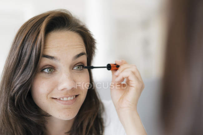 Mulher bonita aplicando maquiagem, usando rímel — Fotografia de Stock
