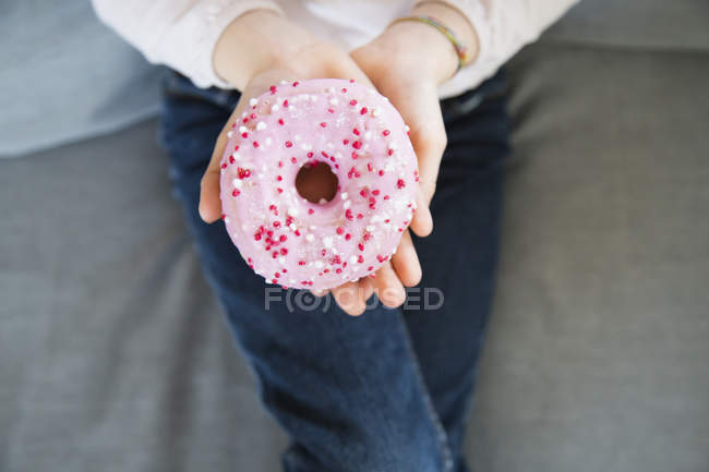 Mädchenhand hält rosa Donut, Nahaufnahme — Stockfoto