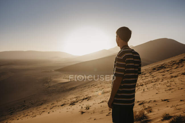 Namibia, Namib desert, Namib-Naukluft National Park, Sossusvlei, man standing at Dune 45 at sunrise — Stock Photo
