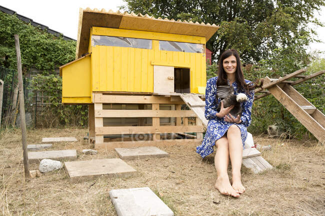 Porträt einer lächelnden Frau mit polnischen Hühnern im Hühnerstall im Garten — Stockfoto