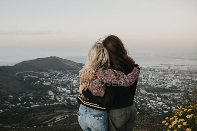 Южная Африка, Кейптаун, Клуф-Нек, вид сзади двух женщин на закате — стоковое фото