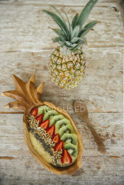 Smoothie Bowl with mango and pineapple garnished with kiwi, strawberries, chia and sunflower seed — Stock Photo