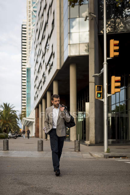 Empresario con bolsa caminando por la ciudad - foto de stock