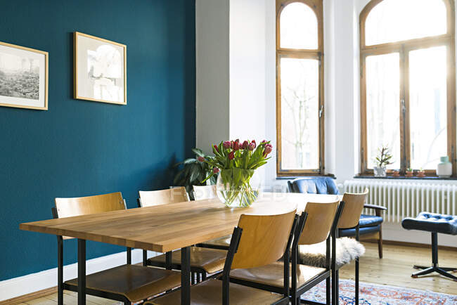 Mesa de madera y sillas con gran ventanal en la sala de estar moderna en elegante apartamento - foto de stock
