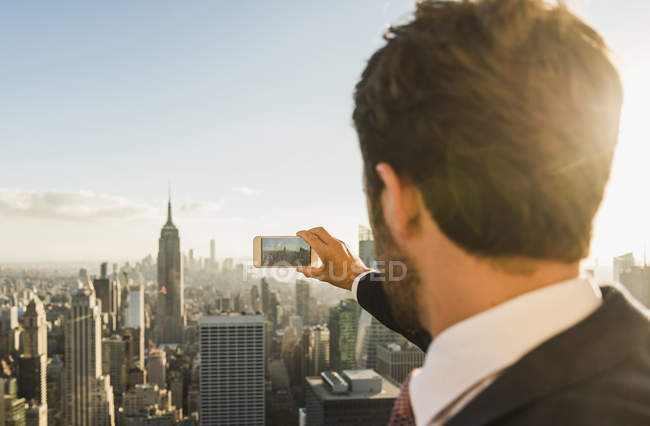 USA, New York, uomo che scatta foto al cellulare sul ponte di osservazione del Rockefeller Center — Foto stock