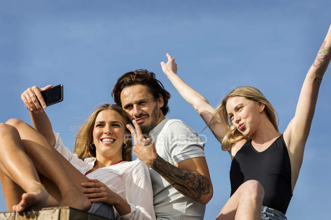 Friends having fun on a rooftop terrace, taking selfies — Stock Photo