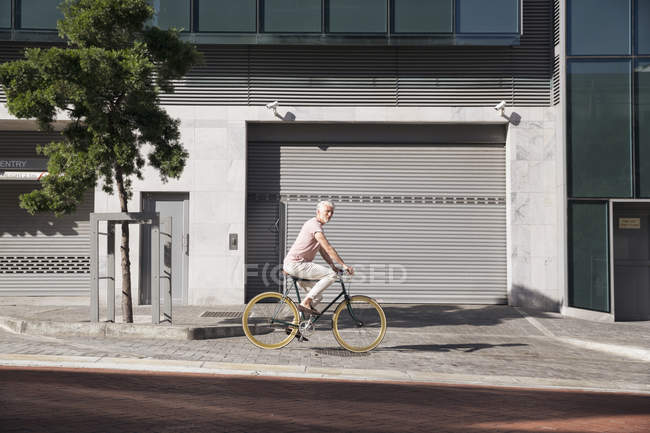 У місті дорослий чоловік їздить на велосипеді. — стокове фото