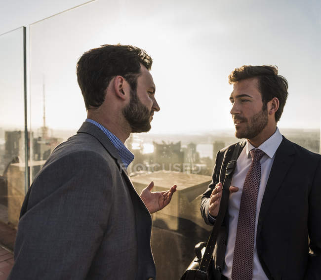 Estados Unidos, Nueva York, dos hombres de negocios hablando en la plataforma de observación del Rockefeller Center - foto de stock
