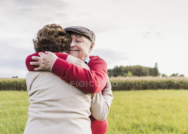 Couple sénior embrasser dans le paysage rural — Photo de stock