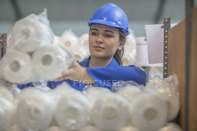 Жінка в жорсткому капелюсі перевіряє кулі на заводі — стокове фото