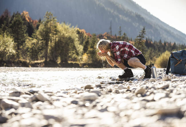 Autriche, Alpes, femme en randonnée faisant une pause dans un ruisseau — Photo de stock