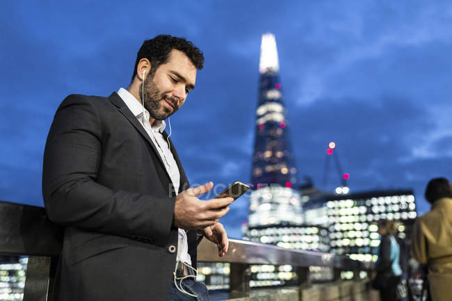 Regno Unito, Londra, uomo d'affari in viaggio controllando il suo telefono mentre si spostava di notte — Foto stock
