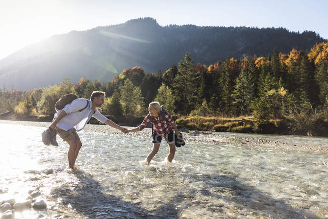 Austria, Alpi, coppia in escursione guadando in un ruscello — Foto stock