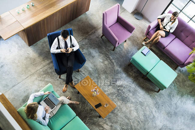 Ansicht von Geschäftskollegen, die an Laptop und Smartphone im Coworking Space arbeiten — Stockfoto