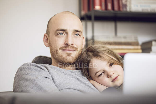 Pai e filha sentados no sofá, usando laptop — Fotografia de Stock