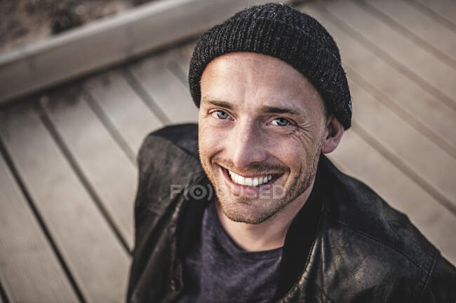 Portrait of smiling man with stubble wearing woolly hat — Stock Photo