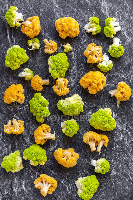 Fleurs de chou-fleur jaune et vert vif sur ardoise — Photo de stock